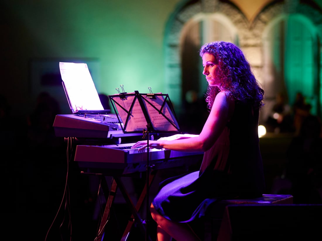 Gabriela Fernandes ao teclado num evento noturno